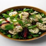 Картофельный салат с горчицей и колбасой в майонезе, посыпанный сыром и зеленью